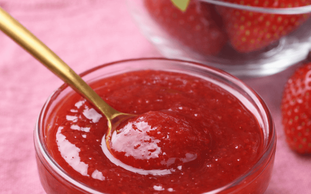 Selbst gemachte Erdbeermarmelade in Glas mit frischen Erdbeeren